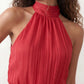 Bella Glossy Halter Mini Dress with a halter mock neckline, tie-back closure, smocked waist, open back, and tiered ruffle mini skirt in a glossy finish, available in Beige, Red, Purple, Yellow, Pink, and Light Blue.