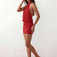 Woman wearing the Mae silk halter mini dress featuring a draped halter neckline, open back with adjustable tie-neck fastening, fitted bodycon mini silhouette, and smooth silk-look fabric, ideal for weddings, cocktail parties, and evening occasions.