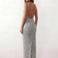 Woman wearing the Mihaela sequined low back maxi dress featuring allover sequin mesh, a square neckline, wide shoulder straps, a low open back, and a fitted floor-length sheath silhouette.