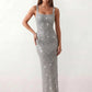 Woman wearing the Mihaela sequined low back maxi dress featuring allover sequin mesh, a square neckline, wide shoulder straps, a low open back, and a fitted floor-length sheath silhouette.