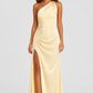 Woman wearing a soft beige asymmetric maxi dress with a one-shoulder neckline, fitted bodice, elegant draped silhouette and thigh-high side split, styled for weddings, evening events and formal occasions.