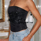 Women’s black strapless bustier top featuring shimmering beaded embellishments, faux boning, a lace-up corset back, and a fitted silhouette for party and evening wear.