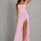 Women’s floral ruched maxi dress featuring rose appliqué accents, cascading asymmetric ruffles, adjustable straps, and a flowing silhouette for weddings and summer occasion wear.