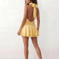 Bella Glossy Halter Mini Dress with a halter mock neckline, tie-back closure, smocked waist, open back, and tiered ruffle mini skirt in a glossy finish, available in Beige, Red, Purple, Yellow, Pink, and Light Blue.