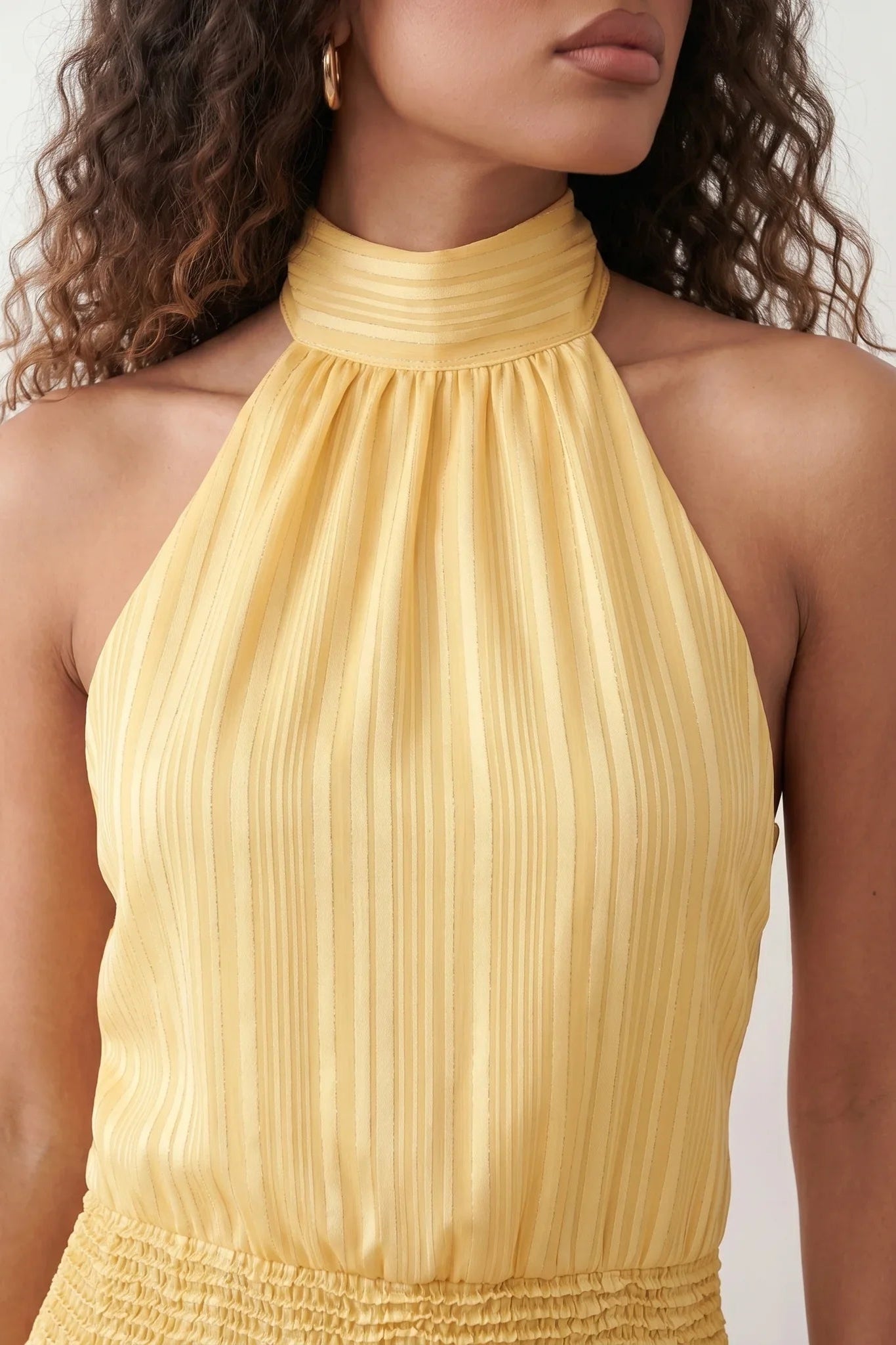 Bella Glossy Halter Mini Dress with a halter mock neckline, tie-back closure, smocked waist, open back, and tiered ruffle mini skirt in a glossy finish, available in Beige, Red, Purple, Yellow, Pink, and Light Blue.